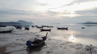 Aerial drone view of tropical coast with long tail fishing boats. Phuket island, Thailand. Beautiful sea surface.