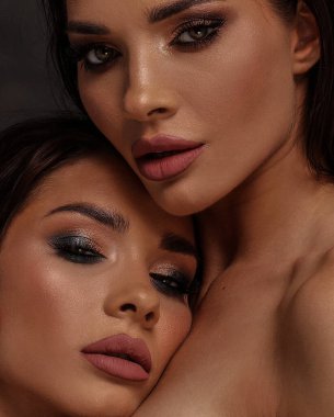 Beauty portrait of two beautiful young women with glamour makeup . Twin sisters. 