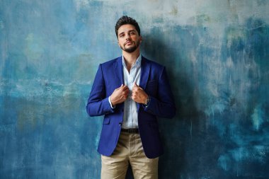 Kendine güvenen zarif, şık takım elbiseli genç adam kameraya bakıyor. Bir sürü kopyalama alanı