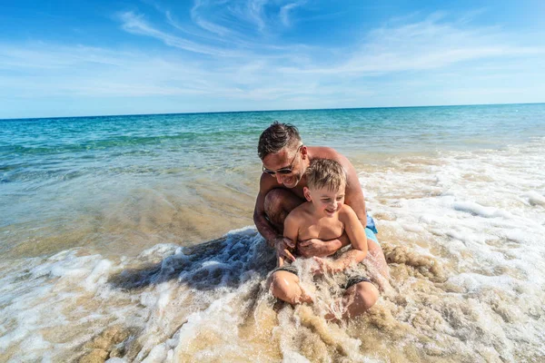 笑我和小孩在海里玩得很开心爸爸和儿子在海滩上玩耍 暑期活动 真正的人的生活方式旅游业 — 图库照片