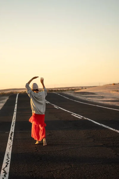冒険の概念 ヒッピーの女性のバックビューだけで 裸足で高速道路を歩いて ダンス 日没の光 夏の雰囲気 — ストック写真