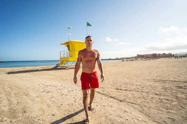 Красивий Чоловік Гуляє Розслабився Піщаному Пляжі Після Купання Океані Рятувальник — стокове фото