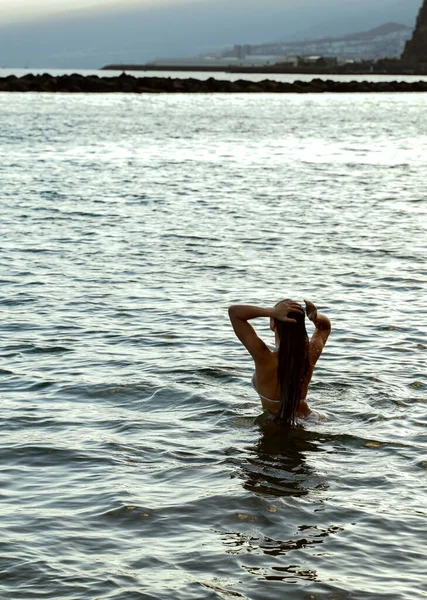 一个女孩在日落后在海里放松和游泳的照片 游手好闲嬉皮的生活 背景色 — 图库照片