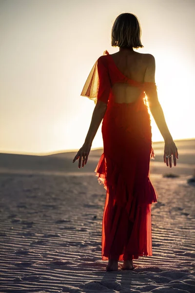 Романтическая Женщина Красном Макси Платье Позирующая Песчаной Пустыне Закате Солнца — стоковое фото