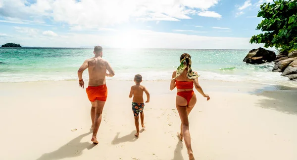 가족들 해변에서 즐거운 시간을 보내고 있습니다 아버지 어머니 아들이 달아나요 — 스톡 사진