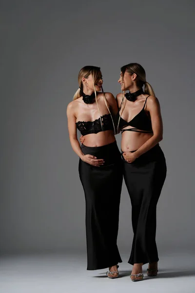 Vrolijke Mooie Zwangere Tweelingzussen Zwarte Modieuze Elegante Kleren Die Samen — Stockfoto