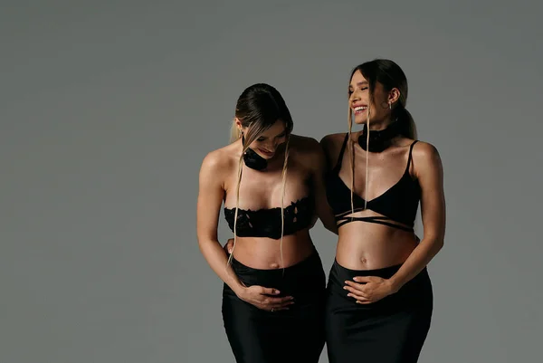 Glückliche Schöne Schwangere Zwillingsschwestern Schwarzen Modischen Und Eleganten Kleidern Posieren — Stockfoto