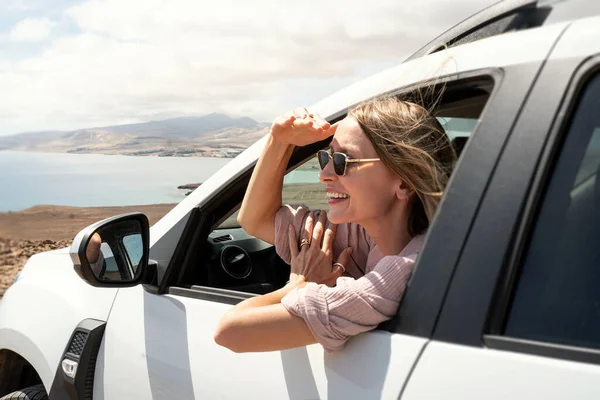 Arabadaki mutlu kadın seyahat ederken pencereden bakıyor. Yolculuk konsepti. Turizm. Gezgin. 