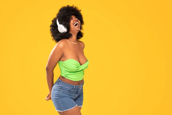 Αξιολάτρευτη Αφροαμερικανή Γυναίκα Λευκά Ακουστικά Γελάει Δυνατά Χορεύοντας Κίτρινο Ζωντανό — Φωτογραφία Αρχείου