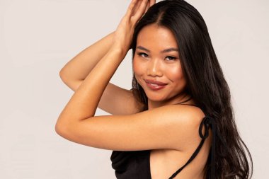 Zarif gülümsemeli Cazibeli Model Yüz Portresi, Dolgun Dudaklar. Güzellik kapanışı fotoğrafı. Uzun saçlı Asyalı kadın kameraya bakıyor.. 