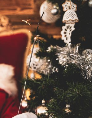 Noel fotoğrafı Xmas ağacının yanında parıldıyor.