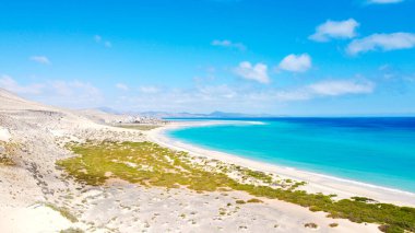 Kanarya adalarından insansız hava aracı atışı. Fuerteventura adasının kıyısındaki Sotavento plajı. Doğal güneşli ışık. Mavi gökyüzü ve kumullar. Kıyı şeridi. Üst düzey seyahat hedefi.