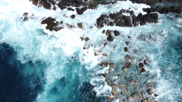 Güçlü ve güçlü okyanusların devasa dalgalarla dolu havadan çekilmiş fotoğrafı. Taşlar. Fırtınalı su. Üst görünüm.