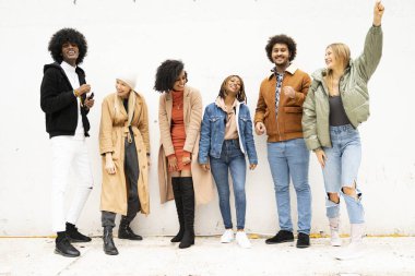 Mutlu milenyum dostları dışarıda eğleniyor, gülüyor ve gülümsüyor. Şehir yaşam tarzı, takım, çok ırklı, arkadaşlık konsepti. Gerçek insanlar..