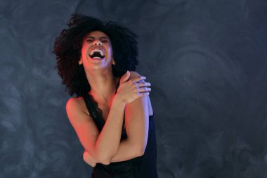 Aşırı neşeli afro kadın yüksek sesle gülüyor. Gerçek insanların duyguları ve mutluluk konsepti. Parti zamanı. Boş zamanlarımızda. Stüdyo çekimi. 