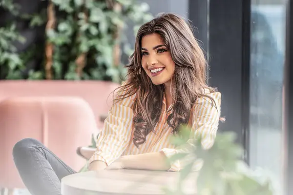 Güzel, hoş görünümlü esmer kadın, kafede neşeli bir yüz ifadesi var..