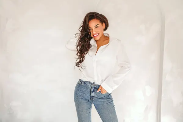 Schöne Frau Posiert Weißem Hemd Und Jeans Lässig Eleganter Look lizenzfreie Stockfotos