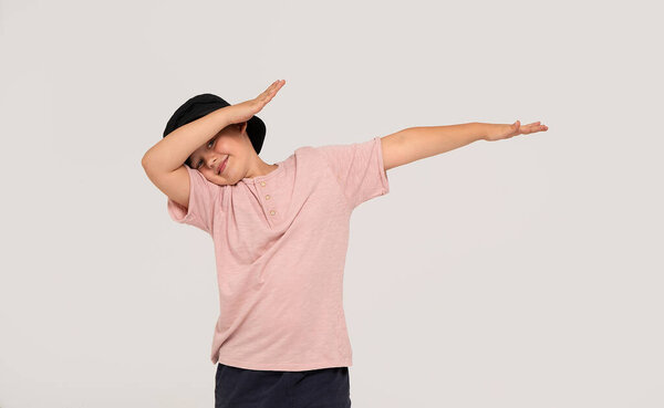 Портрет милого маленького мальчика в стильной одежде, расправляющего руки и веселящего, студийный стадион. Детская мода: много места для копирования