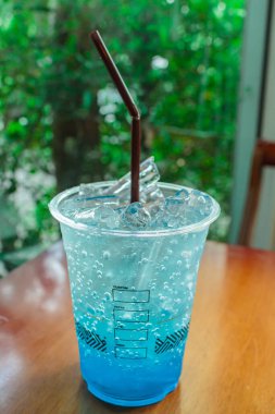 Mavi Hawaii Kokteyli, öğleden sonra çay saatinde renkli İtalyan Meyve Suyu ile barın arka planında.