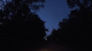 POV gece vakti bulanık cam silecekleri karanlık, korkunç bir yolda uzak ışıklarda.