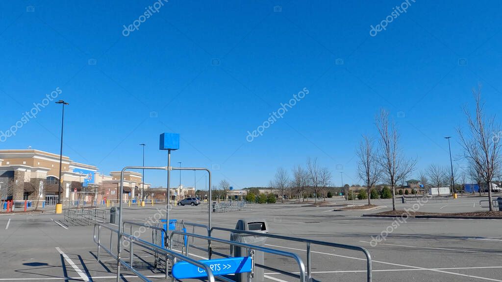 Grovetown, Ga USA - 12 25 22: Walmart supercenter exterior clear blue sky shopping cart coral