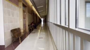 Augusta, Ga USA - 10 27 21: Richmond County courthouse interior lady wearing face mask on phone sitting on a wooden bench