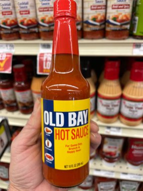 Grovetown, Ga USA - 01 13 23: Grocery store Hand holding Old Bay hot sauce