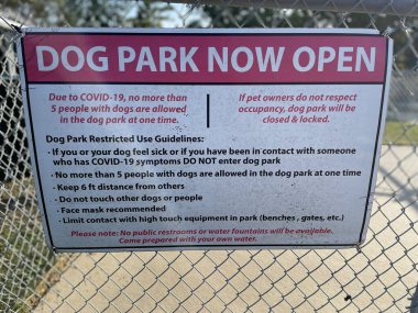 Zincir halkalı çit kuralları ve arka planda köpek parkı tabelası