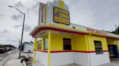 Lakeland, Fla USA - 12-16-23: Hungry Howies Pizza ve Subs restoranı bulutlu gökyüzünü temizledi