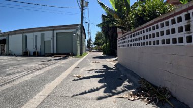 Lakeland, Fla USA - 03-16-24: Dükkan ve binaların arkasındaki arka sokak ve beton çitler