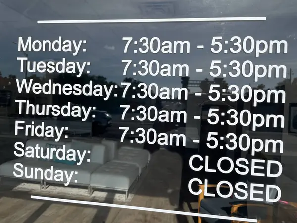 stock image Store hours sign on a glass door closed Saturday and Sunday reflections