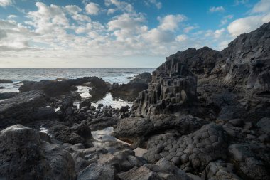  Mavi gökyüzü ile doğal bir kemeri olan kayalık bir sahil. Charco Azul. El Hierro adası. Kanarya Adaları