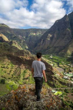Genç adam manzarayı düşünüyor. Agaete Vadisi. Büyük Kanarya. Kanarya Adaları