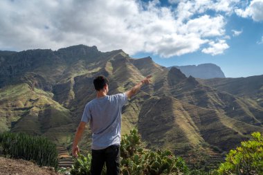 Genç adam manzarayı düşünüyor. Agaete Vadisi. Büyük Kanarya. Kanarya Adaları