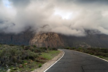 Arka planda alçak fırtına bulutlarıyla kaplı Tirajana dağları. Büyük Kanarya. Kanarya Adaları