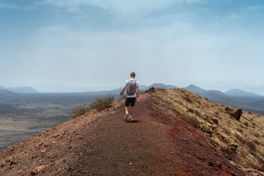 Bir volkanın tepesindeki genç adam. Timanfaya Ulusal Parkı. Lanzarote. Kanarya Adaları
