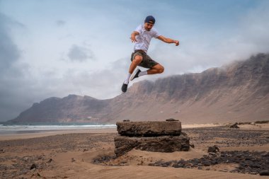 Genç adam Famara plajını ziyaret ediyor. Teg giyin. Lanzarote. Kanarya Adaları. İspanya