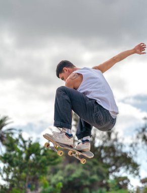Kaykay parkında rampadan atlayan genç bir kaykaycı. dikey bileşim