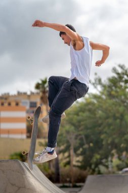 Kaykay parkında rampadan atlayan genç bir kaykaycı. dikey bileşim