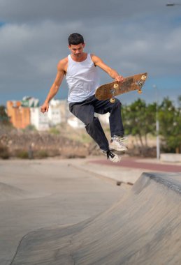 Kaykay parkında rampadan atlayan genç bir kaykaycı. dikey bileşim