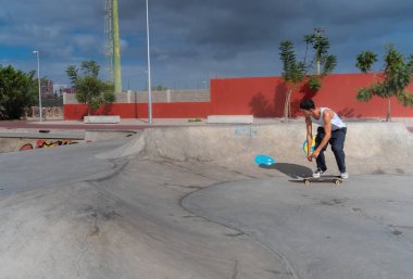 Genç kaykaycı kaykay parkında rampadan atlıyor.. 