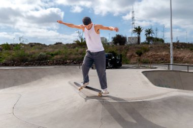 Genç kaykaycı kaykay parkında rampadan atlıyor.. 