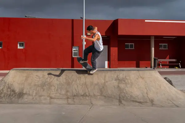 stock image young man skater jumping a ramp in a skate park. vertical composition