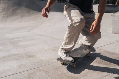 Güneşli bir günde Arinaga kaykay parkında siyah tişört giyen genç bir kaykaycı.