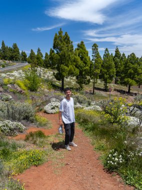 Güneşli bir günde Gran Canaria Adası 'nın tepesinde yürüyüş yapan genç bir adam. Kanarya adaları. İspanya