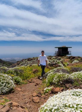 Güneşli bir günde Gran Canaria Adası 'nın tepesinde yürüyüş yapan genç bir adam. Kanarya adaları. İspanya
