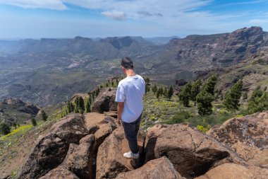 Güneşli bir günde Gran Canaria Adası 'nın tepesinde yürüyüş yapan genç bir adam. Kanarya adaları. İspanya