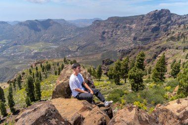 Güneşli bir günde Gran Canaria Adası 'nın tepesinde yürüyüş yapan genç bir adam. Kanarya adaları. İspanya