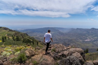 Güneşli bir günde Gran Canaria Adası 'nın tepesinde yürüyüş yapan genç bir adam. Kanarya adaları. İspanya