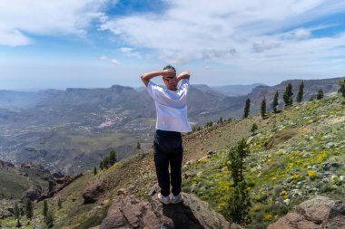 Güneşli bir günde Gran Canaria Adası 'nın tepesinde yürüyüş yapan genç bir adam. Kanarya adaları. İspanya